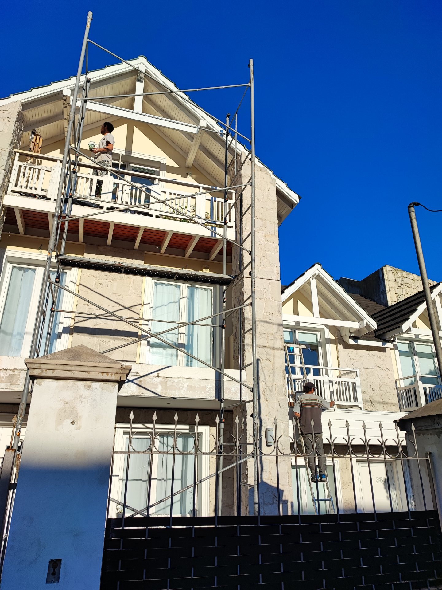 Operarios trabajando con andamio en la reparación y pintura de una fachada en Mar del Plata