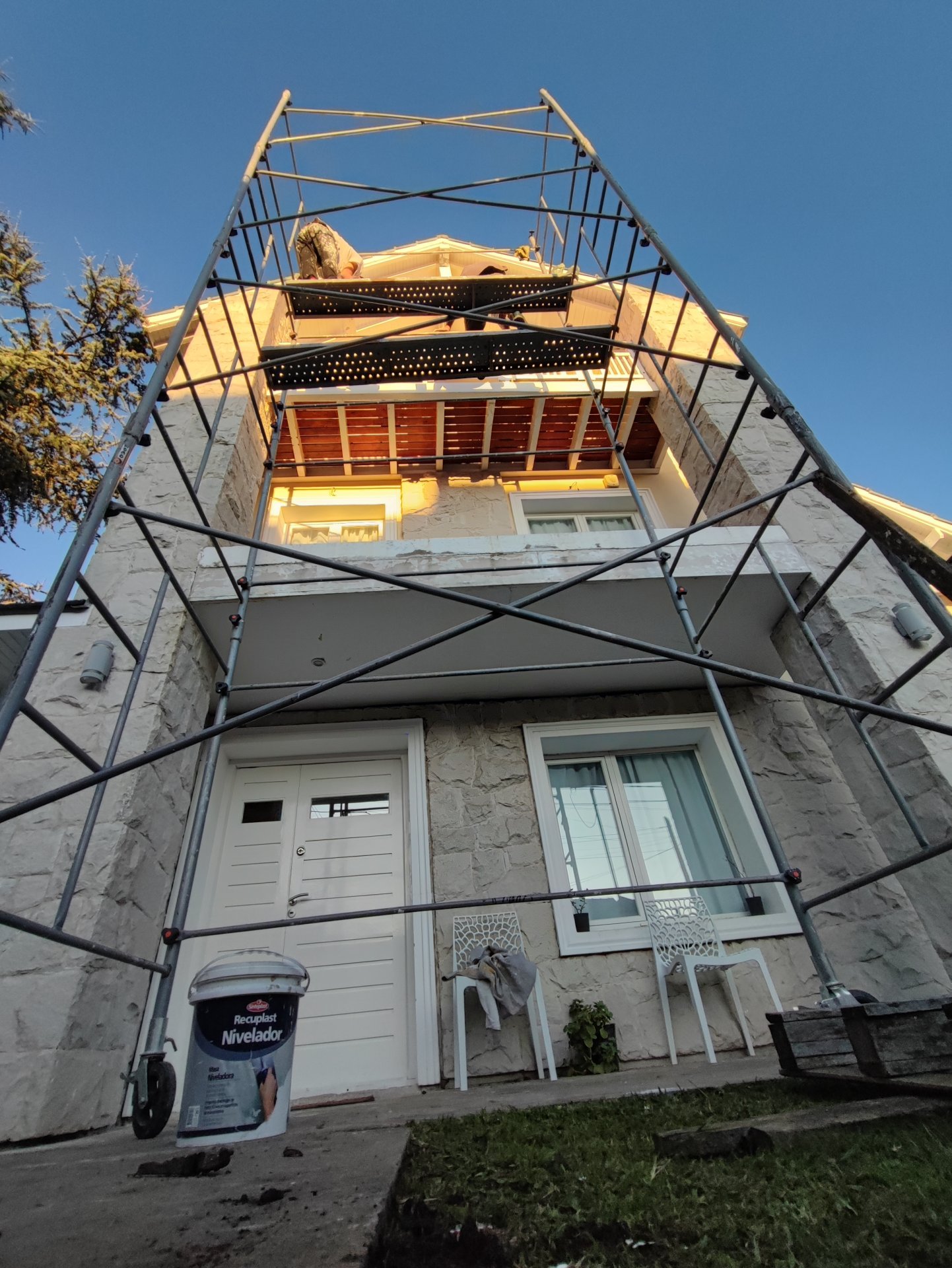 Andamio en fachada de piedra para trabajos en altura al atardecer en Mar del Plata